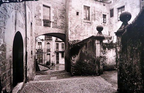 Palau dels Agullana i Pujada de Sant Domènec. Al fons, l'Associació Obrera La Amistat i un grup de nois a l'entrada de l'antic Registre de la Propietat. Girona. 1915-1925
