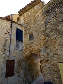 Muralla formada per la fulla vertical original del segle XIII i posterior afegit exterior atalussat del segle XIV a la zona coneguda com del vell transformador