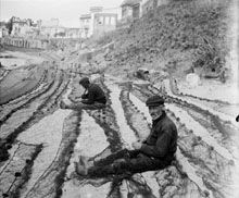 Pescadors reparant les xarxes a la platja. Calella de Palafrugell. 1920