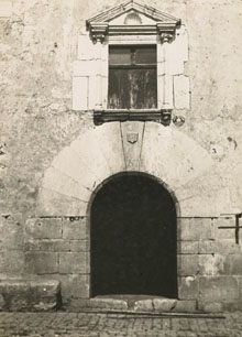 Façana del Mas Serra, amb una portalada amb escut de l'any 1526 i el finestral amb timpà triangular amb una petxina al frontó. 1925