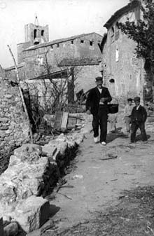 Vista parcial d'Avinyonet de Puigventós amb tres persones al camí. Ca. 1890