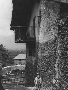 Portal i façana lateral de Les Pareres amb un nen. Ca. 1936