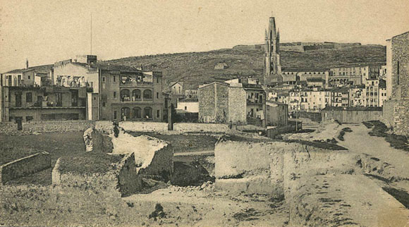Vista parcial del baluard de la Santa Creu en ruïnes poc abans de la seva demolició definitiva. En segon terme, diferents habitatges del barri del Mercadal. 1905-1909
