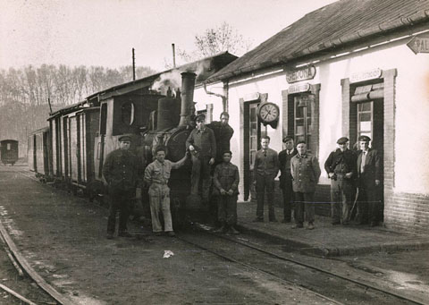 Retrat d'un grup de persones enfilades en una locomotora aturada a l'estació del ferrocarril del tren Palamós-Girona-Banyoles, al barri de Pedret. 1950-1956