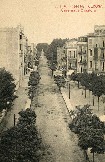 Vista des dun punt elevat de la plaça Marquès de Camps i de la carretera de Barcelona. En segon terme a lesquerra, el Banc dEspanya. Sobserven els plataners plantats a banda i banda del carrer. 1905-1911