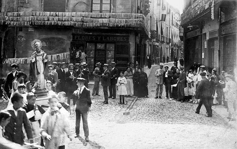 La imatge de Sant Corneli en processó a la plaça de l'Oli dins els actes de la Festa Major de la Cort Reial. L'acompanya una banda de música. 1910