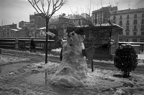 El quiosc de la Rambla de la Llibertat, darrera un ninot de neu. 10/1/1967