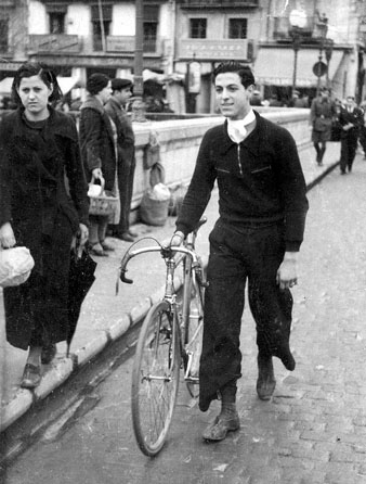 Retrat de Cinta Ferragut i Albert Marull passant pel pont de Pedra amb la seva bicicleta. 1929-1930