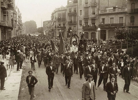 Trasllat a l'Ajuntament de Girona a peu. La comitiva, encapçalada per banderes i estandards, passant per la plaça Marquès de Camps