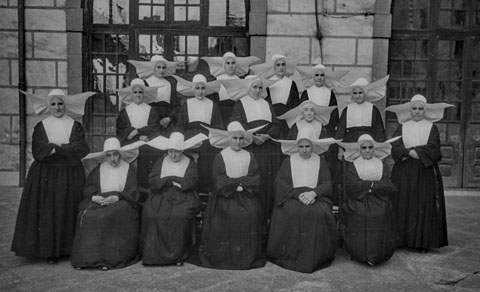 Grup de monges paüles al pati de l'antic Hospici de Girona. 1960