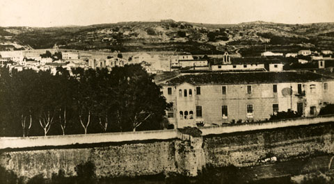 L'edifici de l'Hospici. En primer terme la muralla de l'actual Gran Via de Jaume I. 1890
