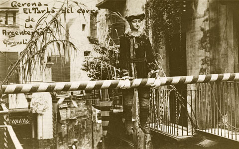 El Tarlà de l'Argenteria, penjat al tram final del carrer. Al fons a l'esquerra, la façana de la farmàcia Masó abans de de la reforma. 1918