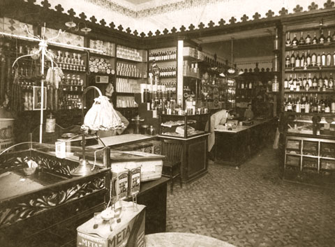 Interior modernista del Colmado Gelabert, al carrer Ciutadans. Josep M. Gelabert i un dependent darrera el taulell de la confiteria. 1900