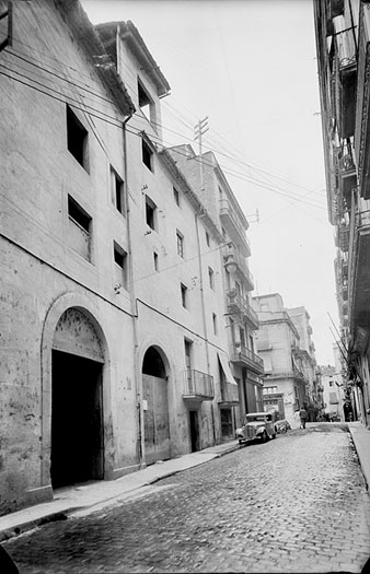 Carrer Santa Clara vist des de la plaça del Molí i en direcció al pont de Pedra. A la dreta, l'edifici de la Caixa de Pensions, i a l'esquerra, la fleca Oriell. 1920