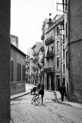 El carrer Santa Clara abans de la seva alineació. L'edifici de l'esquerra formava part de la fàbrica Grober i va ser enderrocat juntament amb l'edifici de la dreta. 1947