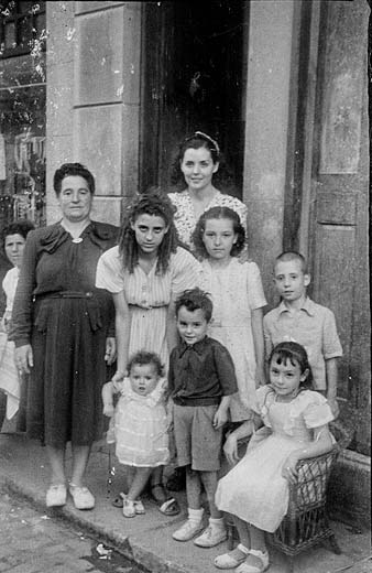 Festa popular del carrer Calderers. Retrat d'un grup de dones i mainada a l'exterior d'un habitatge. 1948