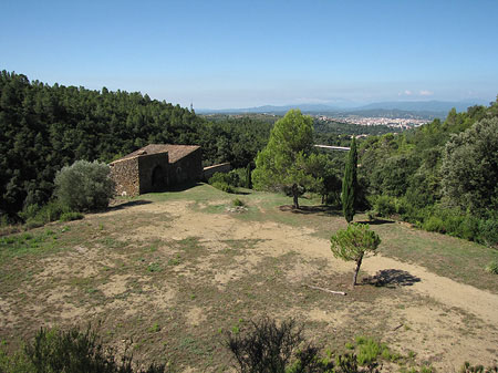 La masia de Can Lliure. Al fons, la ciutat de Girona