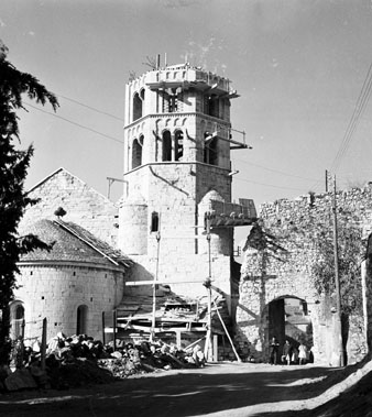 Campanar i absis de l'esgl&eacute;sia de Sant Pere de Galligants en obres. A la dreta el portal de Sant Pere que donava acc&eacute;s a la Vall de Sant Daniel. 1960