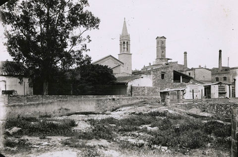 El campanar nou del Mercadal i la Torre de les Aig&uuml;es vistos des de les hortes. A la dreta, la f&agrave;brica Gr&ograve;ber