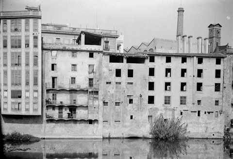 Cases de l'Onyar del carrer Santa Clara. En primer terme, el riu Onyar. Al fons, la torre de les Aig&uuml;es i la xemeneia de la Gr&ograve;ber