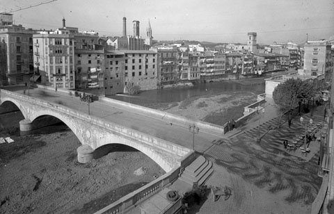 Vista enlairada del Pont de Pedra. Entre la xemeneia de la Gr&ograve;ber i el campanar neog&ograve;tic de Santa Susanna, s'observa la Torre de les Aig&uuml;es
