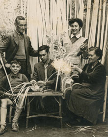 La família Olivas, cistellers de Banyoles, al pati de casa seva al carrer Major de Banyoles, fent palmes per al Diumenge de Rams. Podem veure de dalt a baix i d'esquerra a dreta: Francesc Olivas, Dolors Olivas, Xavier Olivas, Joan Olivas i Caterina Coll. 1945