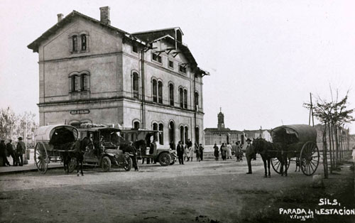 Estació de ferrocarril de Sils. En primer terme s'observen carruatges i automòbils aparcats. 1930-1936